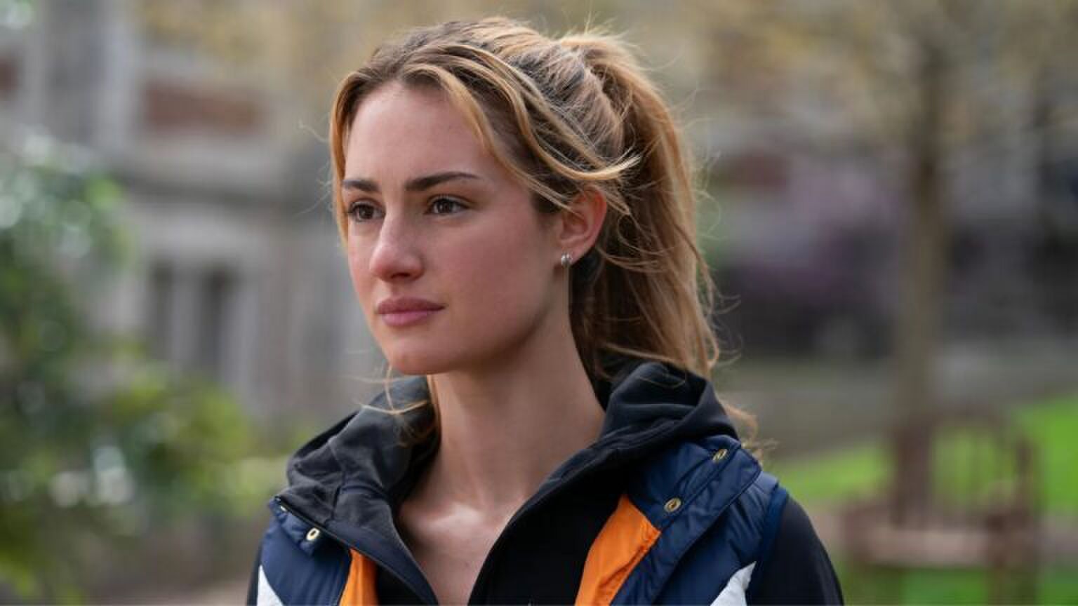 Een jonge vrouw rent door een park.