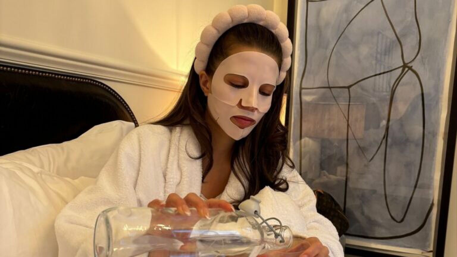 Zara Goedemans zit op bed met een gezichtsmaskertje op.