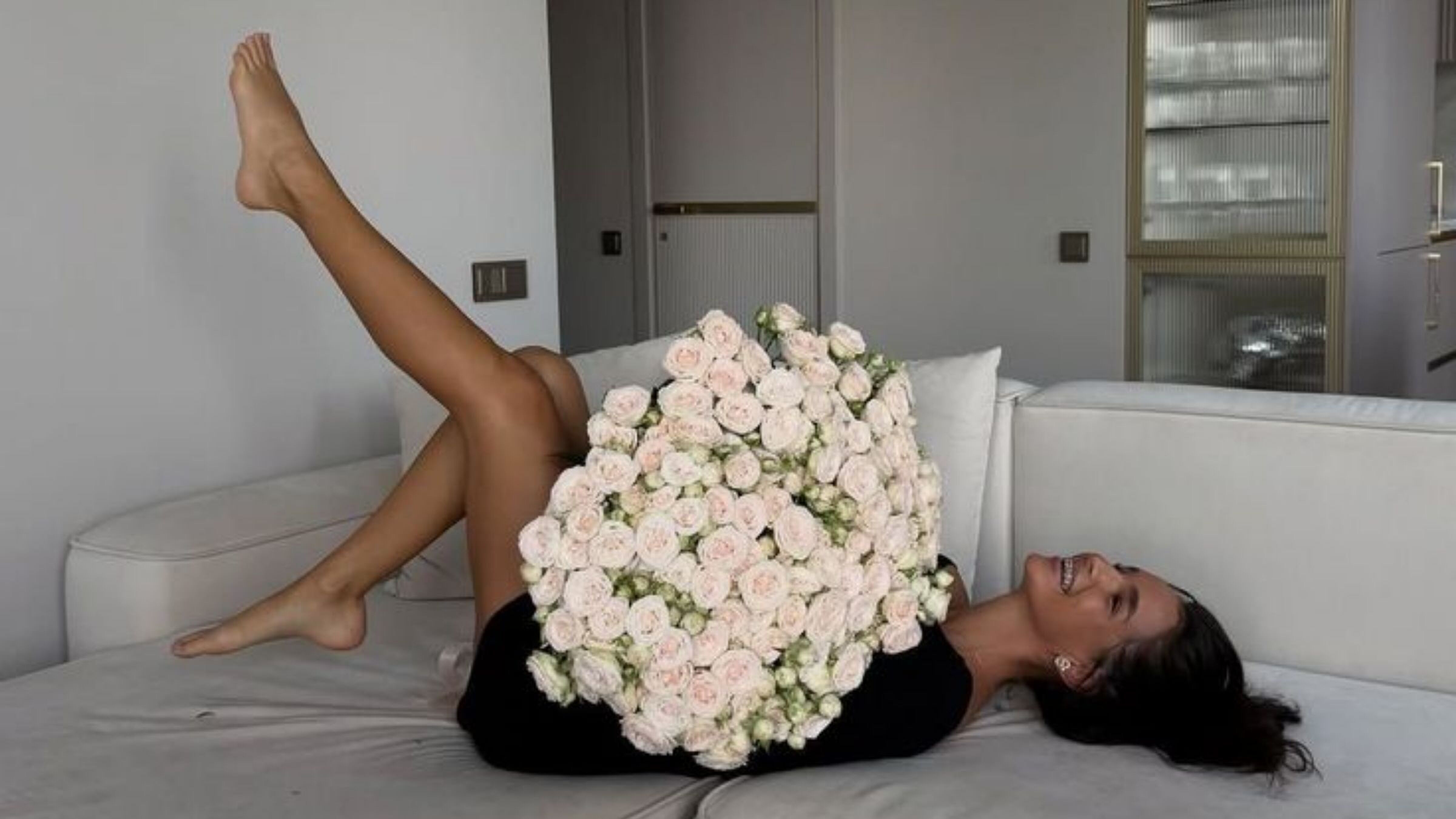 Meisje die met bloemen op een bank ligt.