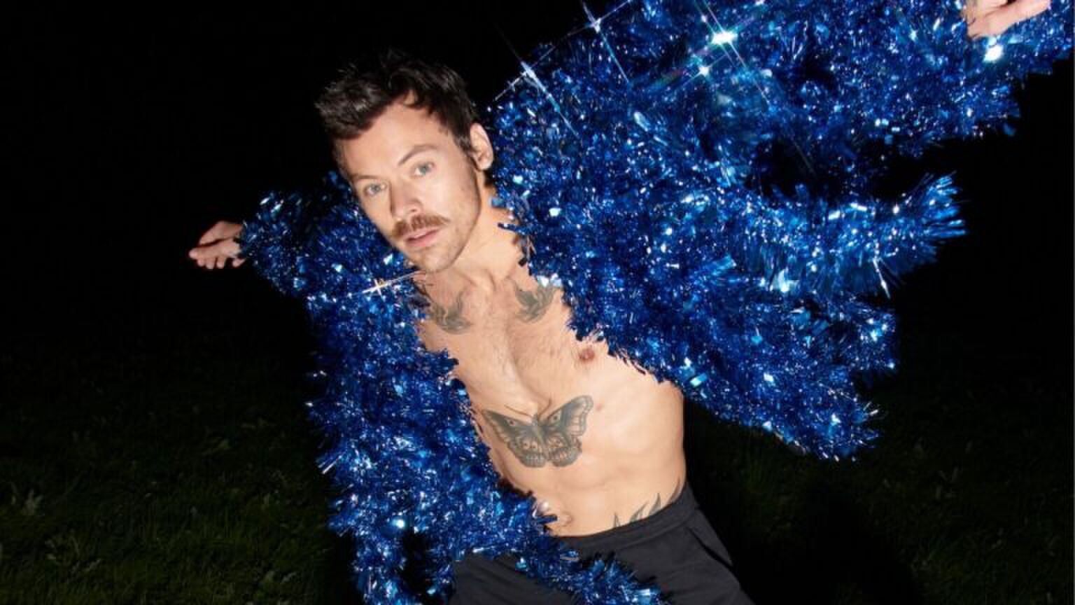Harry Styles in een blauwe glitter jas.