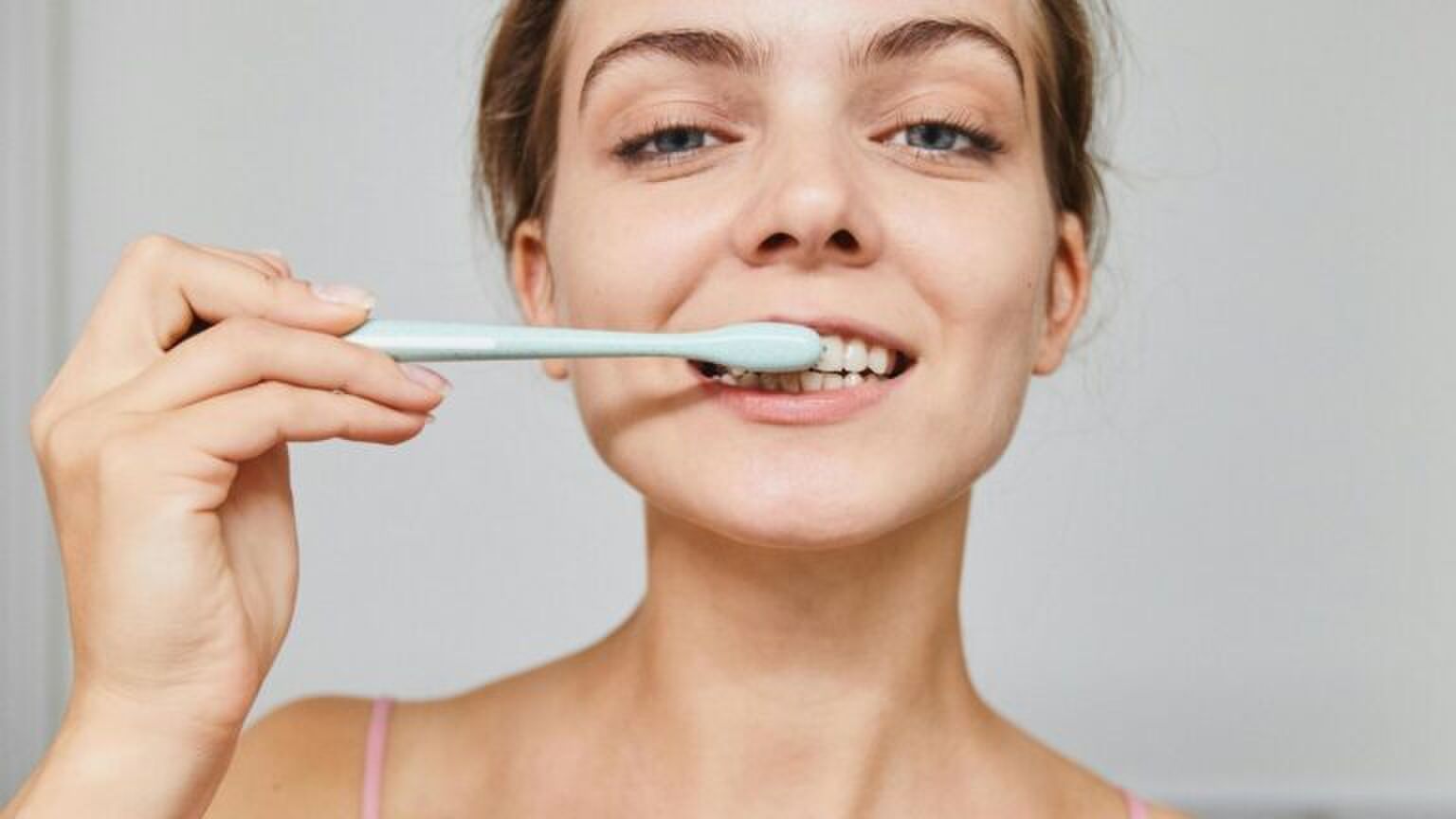 Jonge vrouw poetst haar tanden.