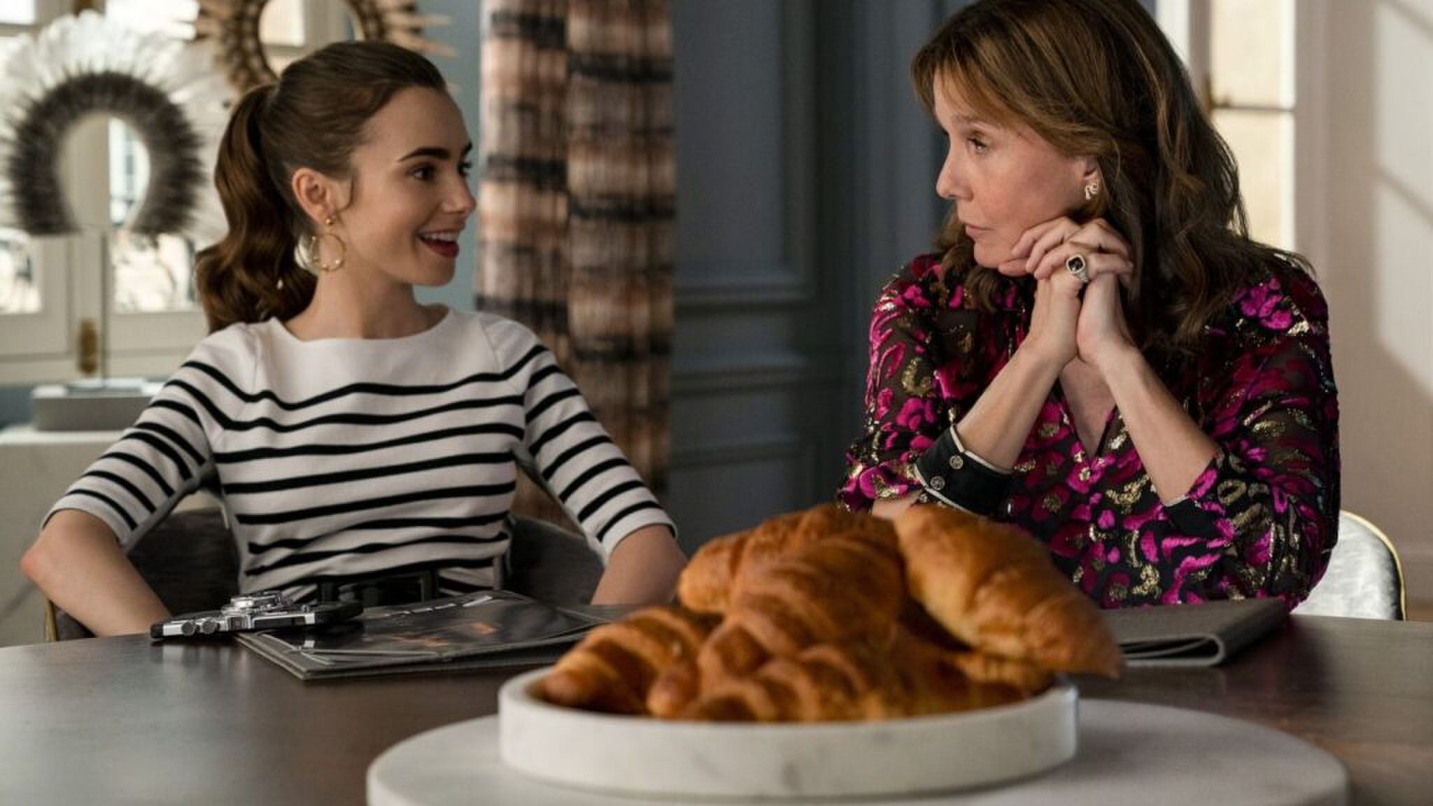 Emily die aan tafel zit met croissantjes voor haar.
