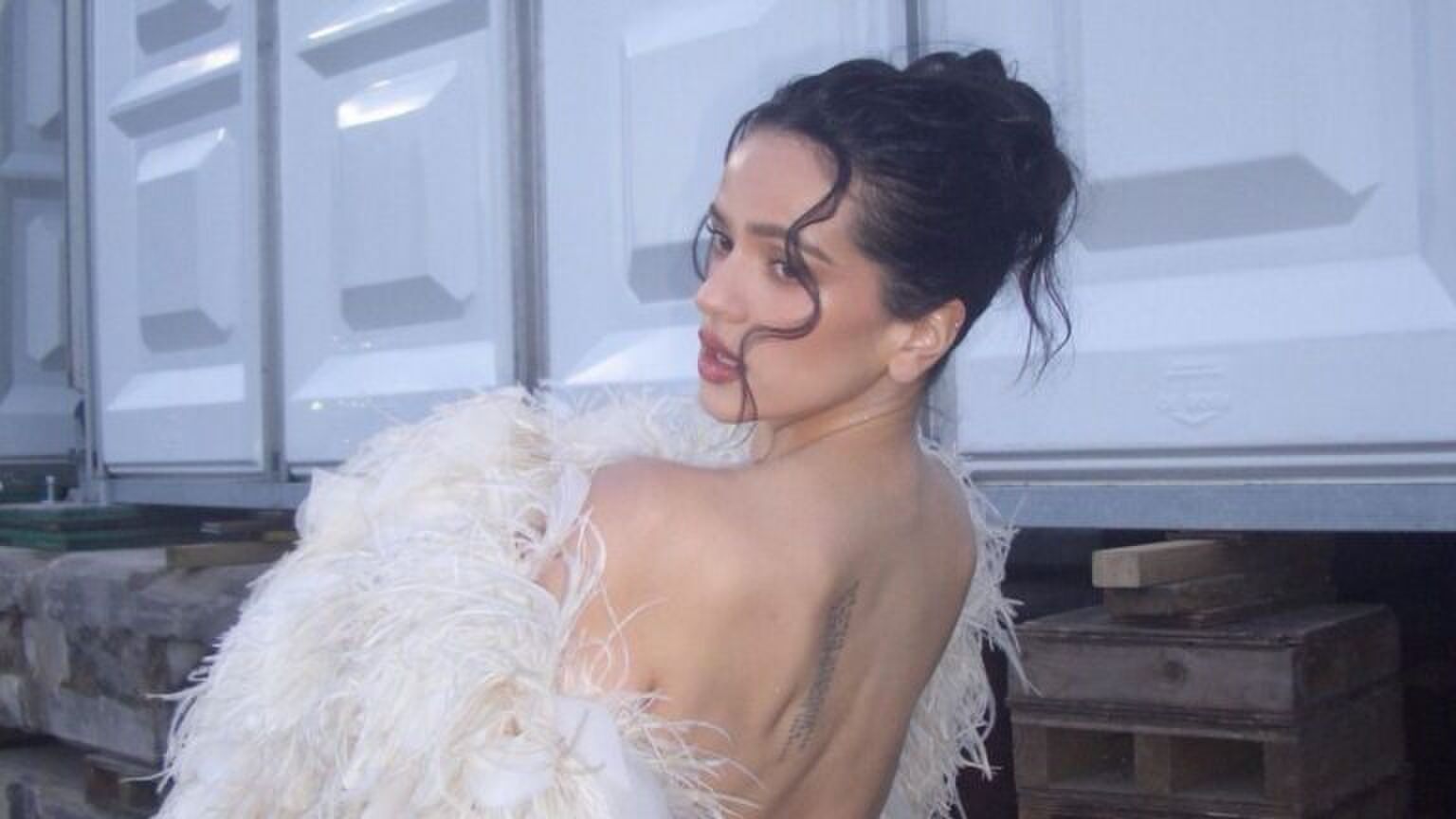 Zangeres Rosalía in een witte jurk.