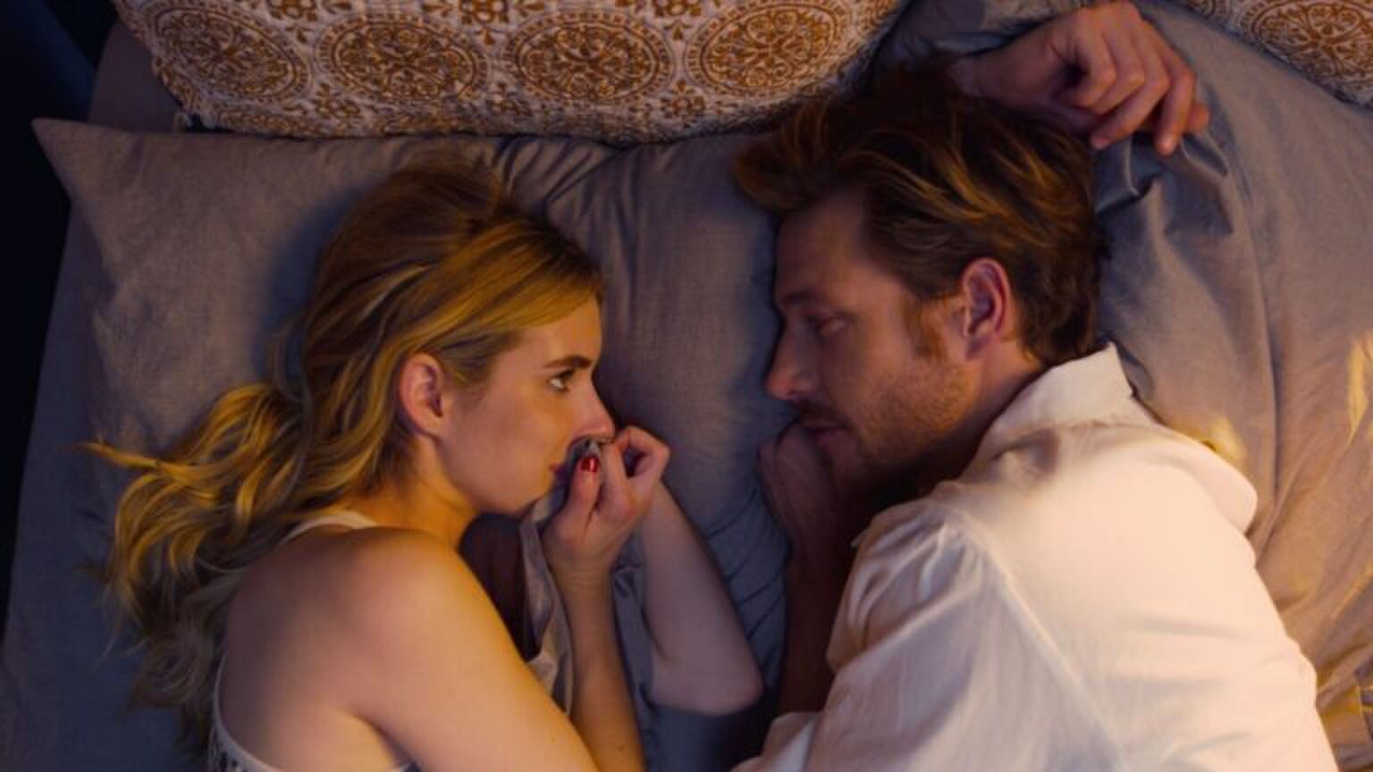 Meisje en man die elkaar aankijken in bed.