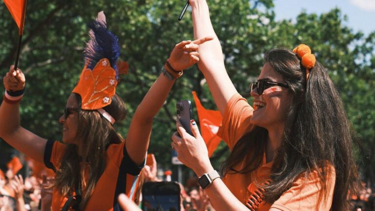 Twee vrouwen zijn aan het feesten tijdens Koningsdag.