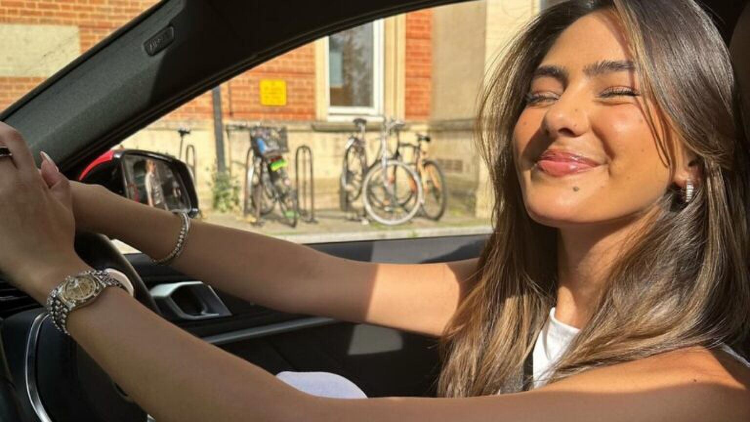 Foto van verslaggever Lissie Mackintosh, ze zit in haar auto en lacht.