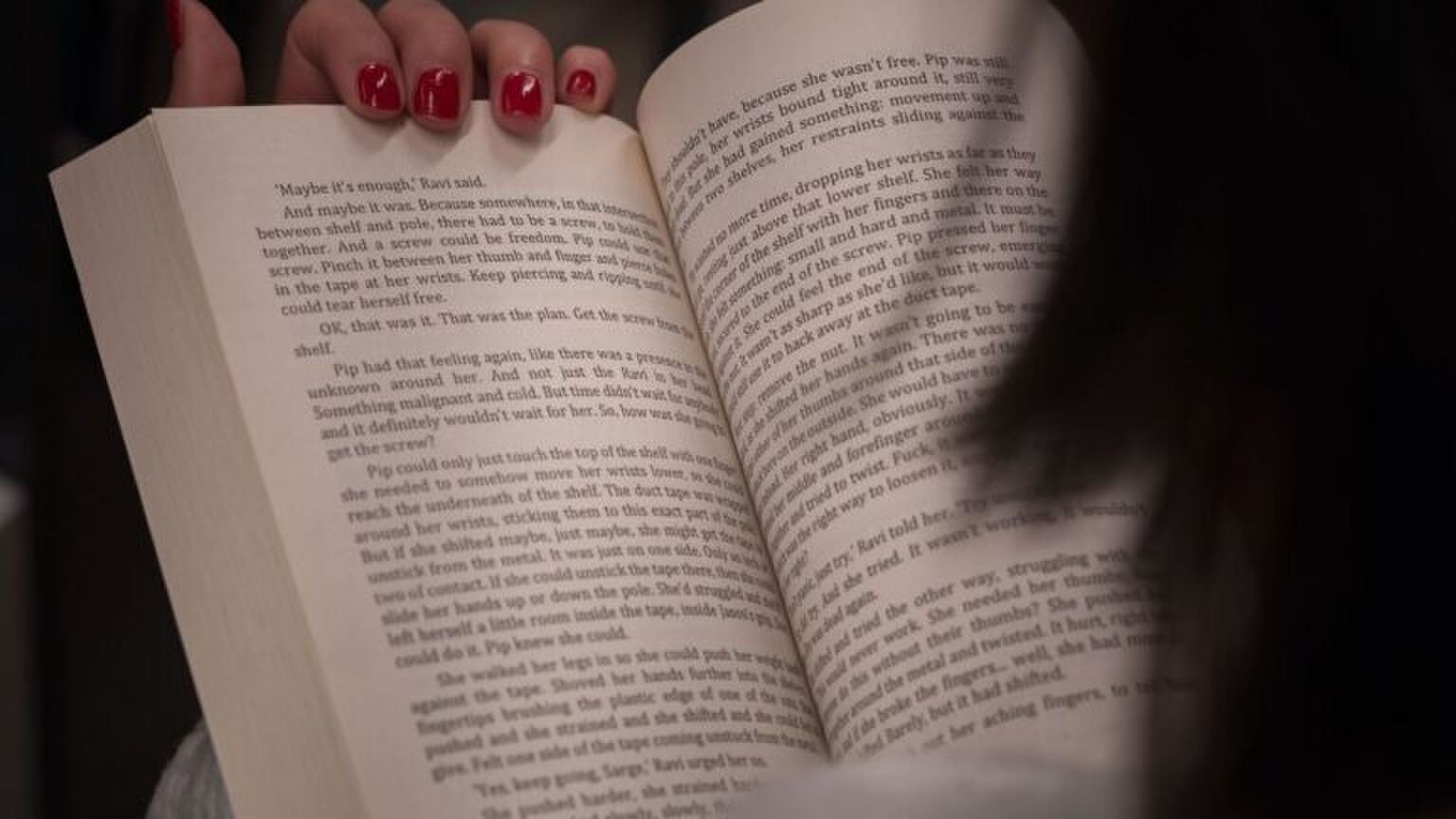 Vrouw leest uit een boek.