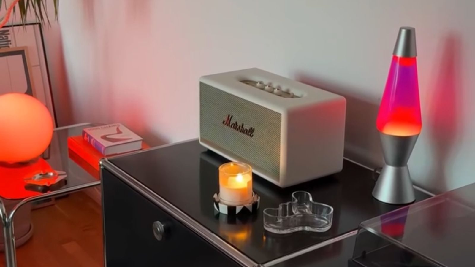 Een lavalamp, stereo en kaars op een kastje.