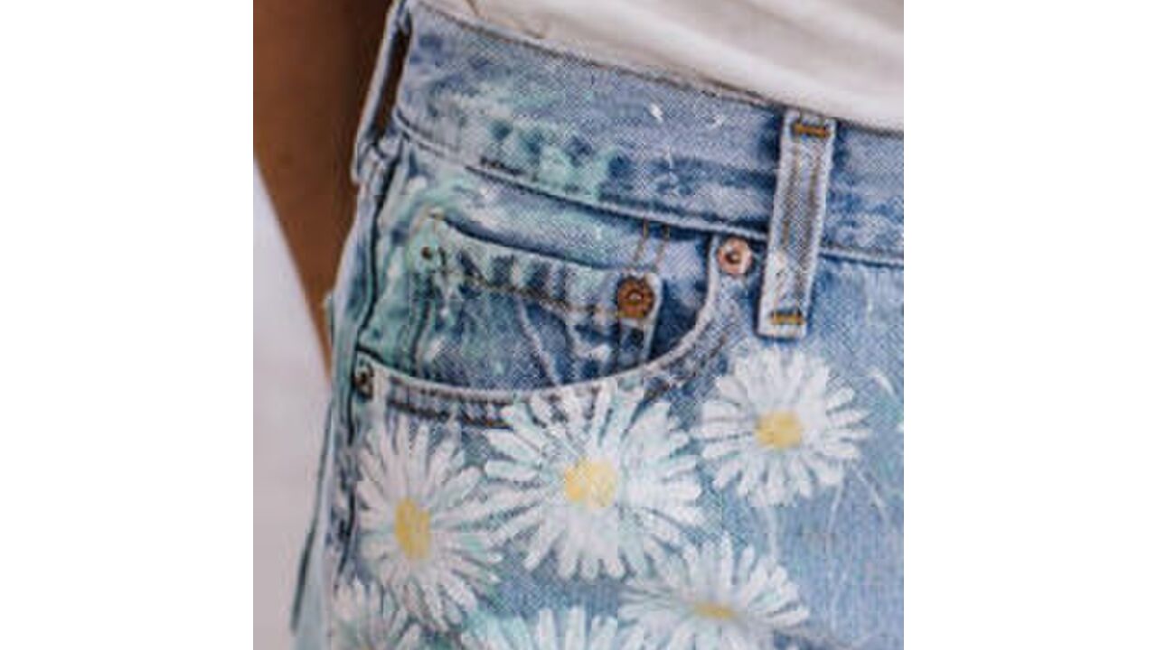 Illustratie voor: Hier zijn de metalen knopen op het kleine broekzakje van jeans voor