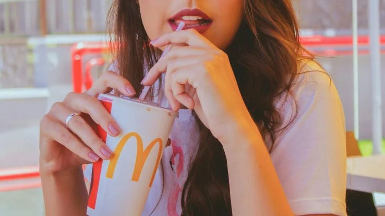 Vrouw zit aan tafel bij de McDonald's.