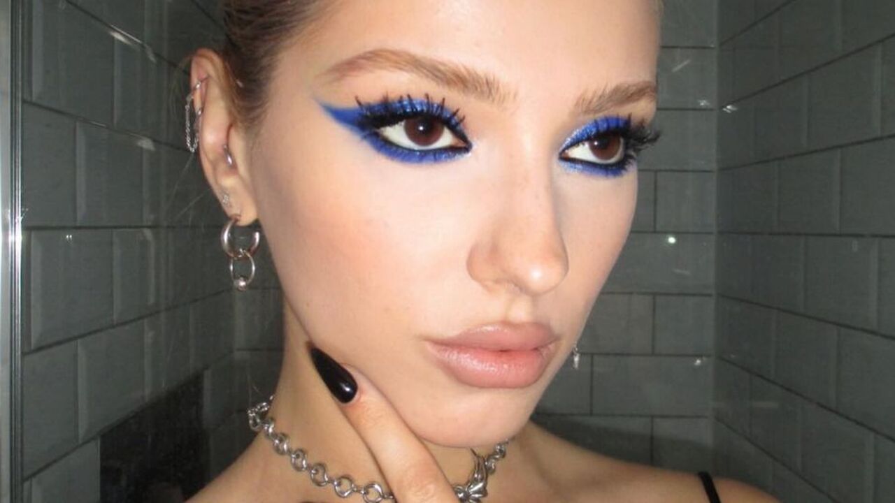 Danielle Marcan met met een party girl make-up look. Blauwe, glitterige oogschaduw en opvallende wimpers.
