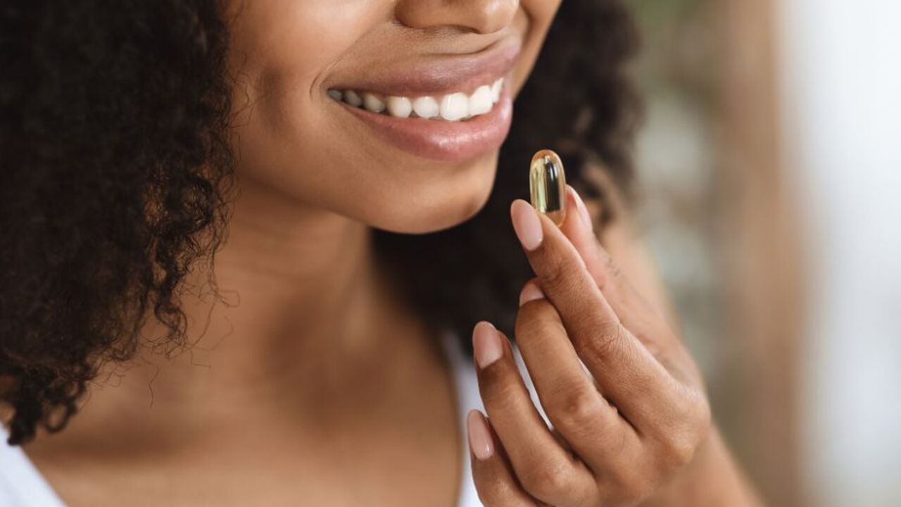 Een vrouw die een supplement gaat slikken.