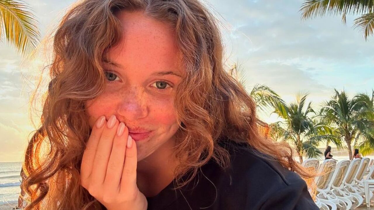 Meisje met krullen op het strand.
