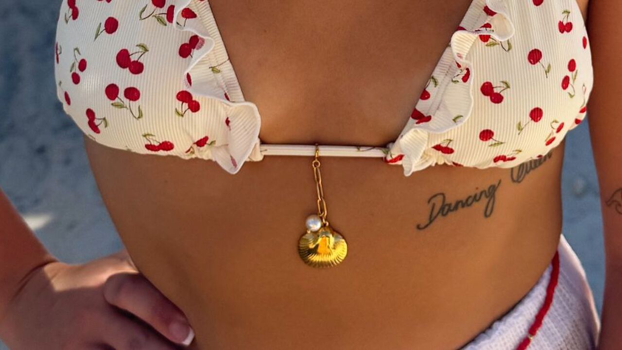 Een vrouw in bikini met een bikini charm aan de bikini.