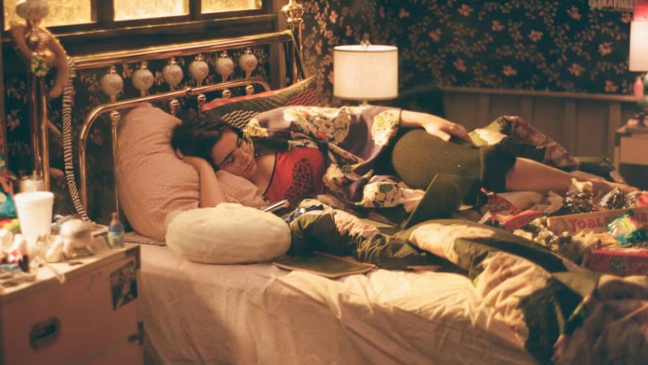 Meisje ligt in bed en kijkt een serie.