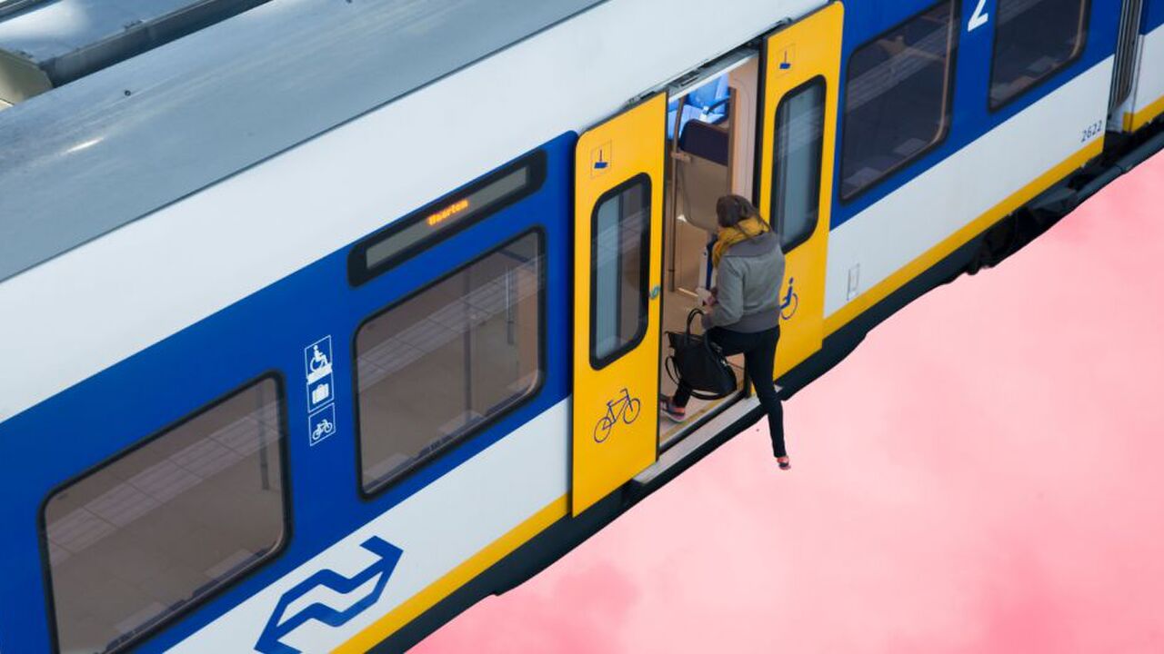 Een vrouw stapt de trein in.