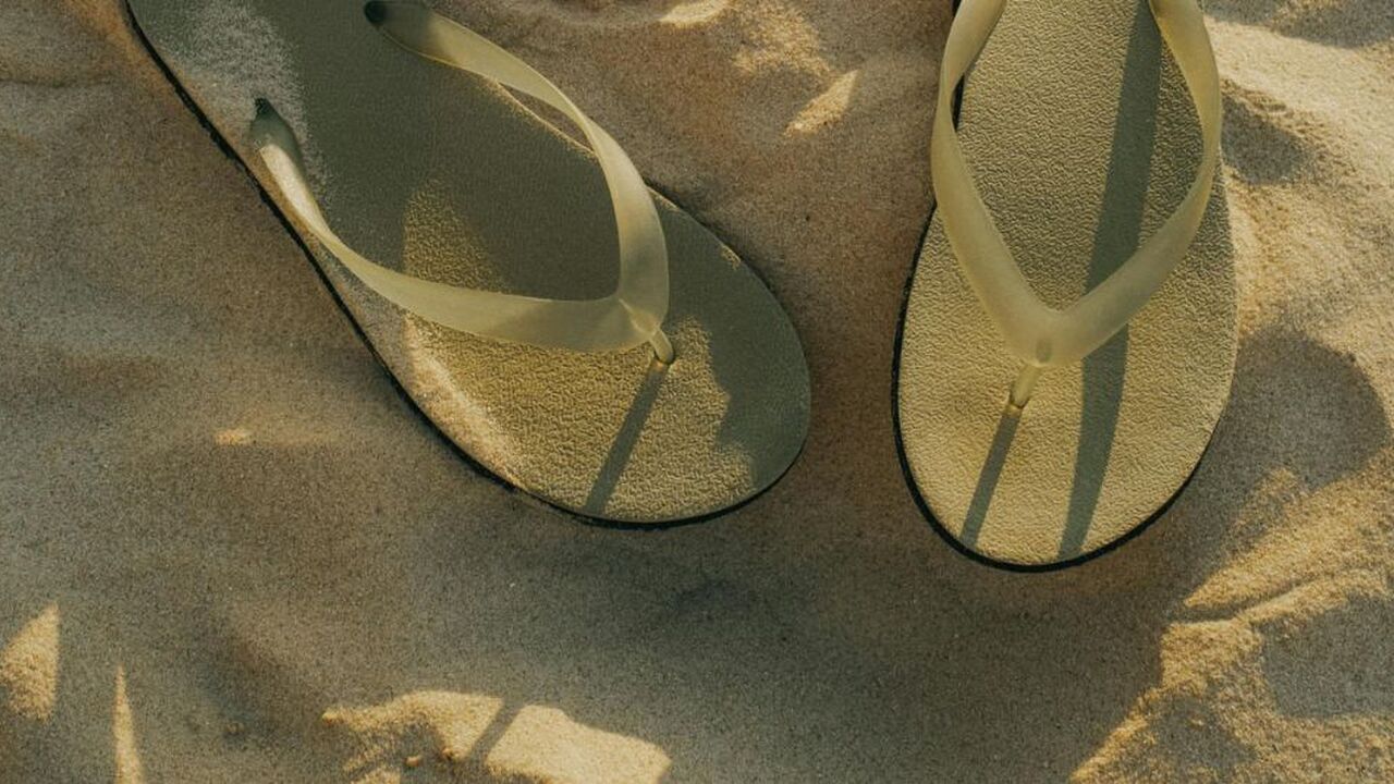 Slippers in het zand.