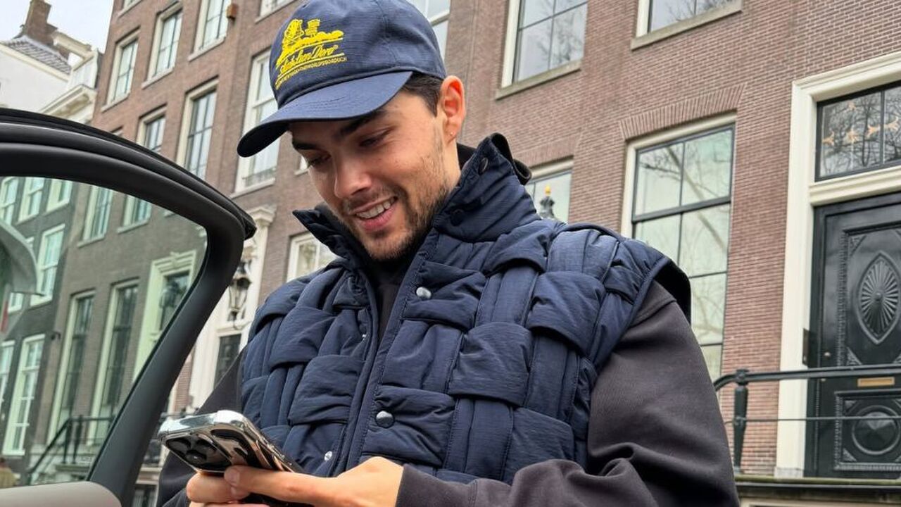 Thijs Boermans kijkt lachend naar zijn telefoon.