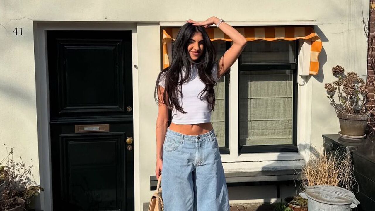 Anna Nooshin staat voor een huis.
