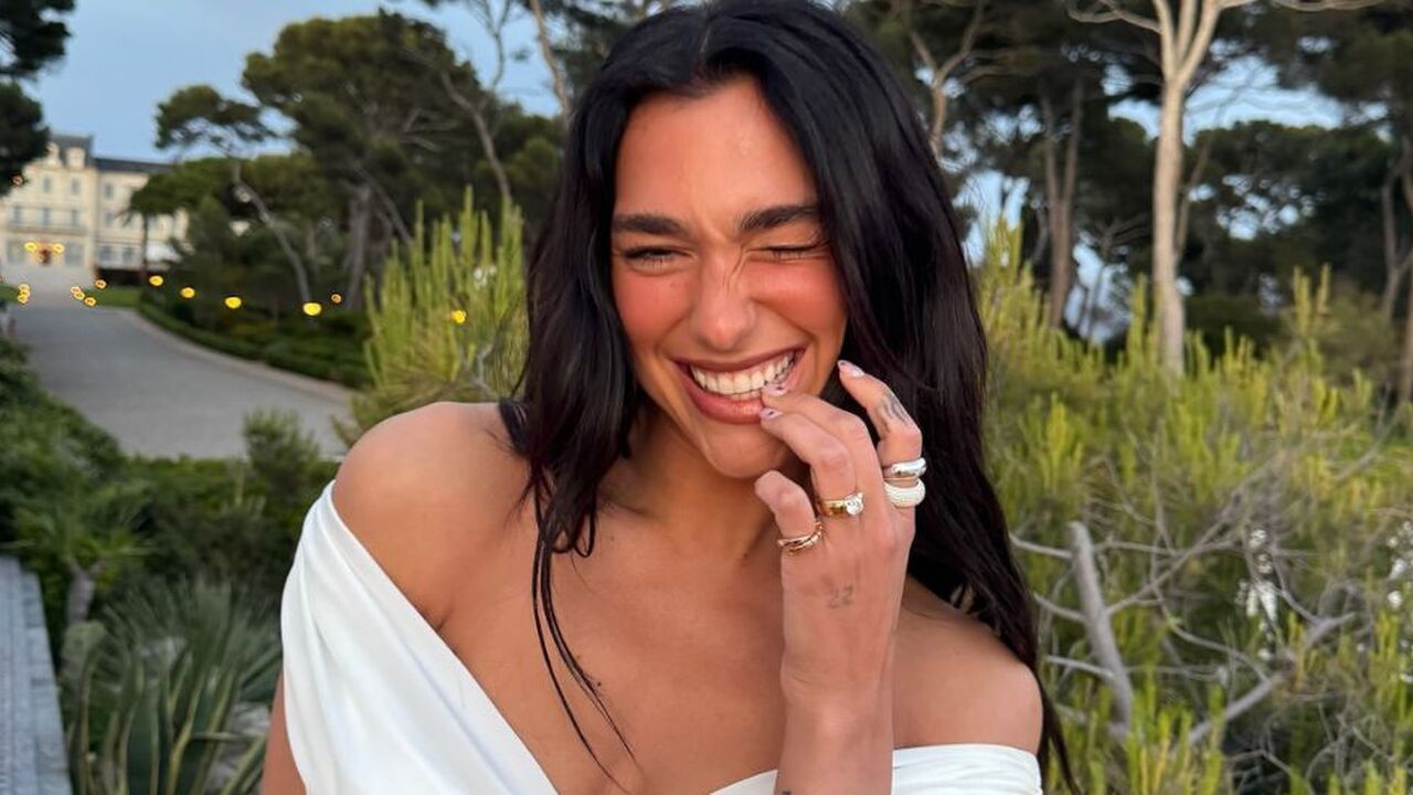 Dua Lipa lacht naar de camera.