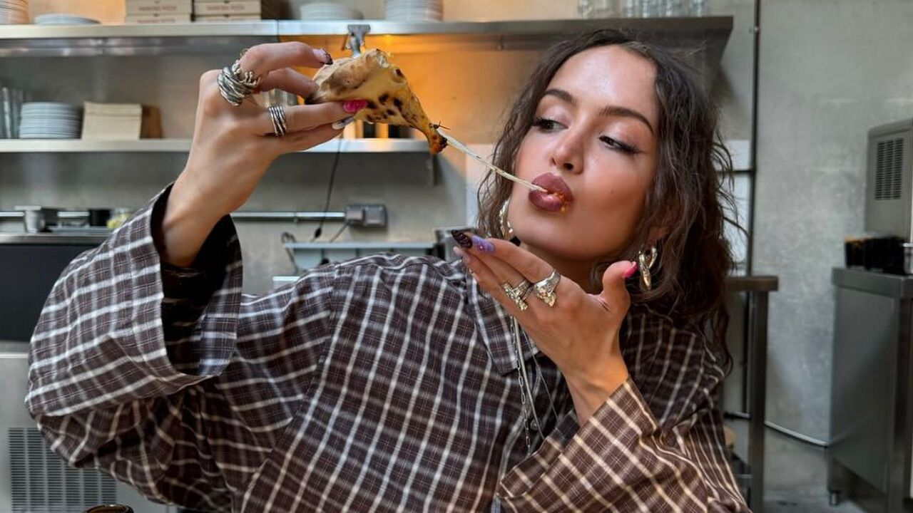 Een vrouw die een pizza aan het eten is.