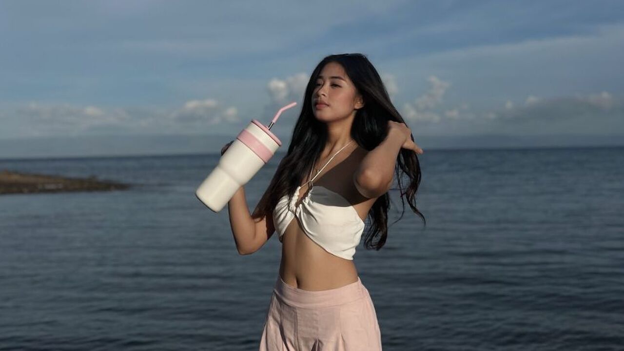 Een vrouw die een waterfles vasthoudt.