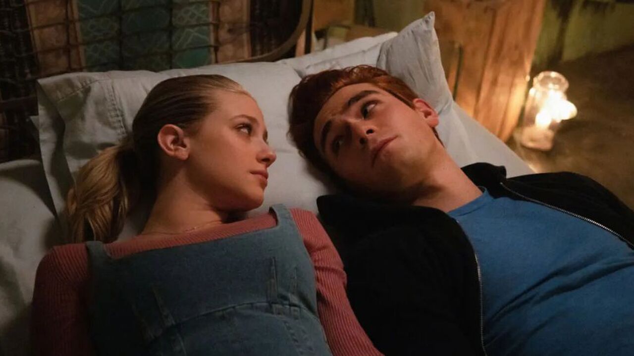 Jongen en meisje liggen op bed en kijken elkaar aan.