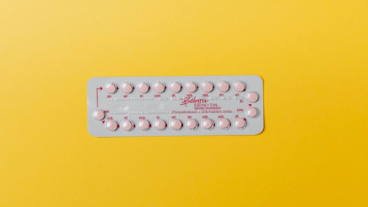 Anticonceptie pil met gele achtergrond.