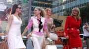Charlotte, Carrie, Miranda en Samantha uit Sex and the City lopen op straat.