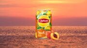 Een blikje Lipton Ice Tea Peach met een zomerse achtergrond.