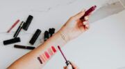 Een vrouw met verschillende kleuren lippenstift op haar arm uitgeprobeerd.