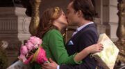 Leighton Meester en Ed Westwick als Blair en Chuck in de serie Gossip Girl. Ze geven elkaar een kus, terwijl ze een cadeau en een bos bloemen vasthouden.