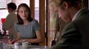 Scène uit Meet Joe Black. Meisje kijkt naar een jongeman die binnenkomt. Ze zit in een koffiezaakje.