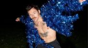 Harry Styles in een blauwe glitter jas.