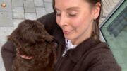 Vrouw die haar hond knuffelt.