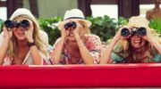 Drie vrouwen met verrekijkers.