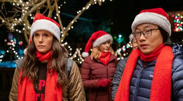 Twee mensen met een kerstmuts op kijken geirriteerd.