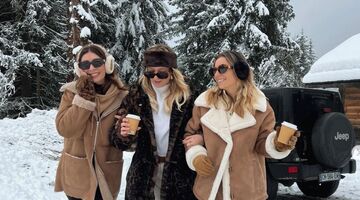 Drie meiden lopen door de sneeuw heen.