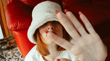 Vrouw drukt haar hand tegen de camera.