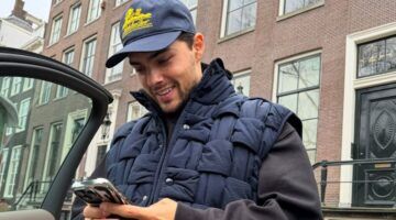 Thijs Boermans kijkt lachend naar zijn telefoon.