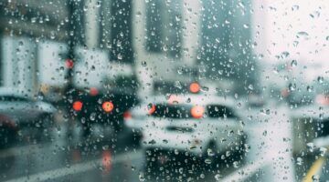 Een auto rijdt door de regen.