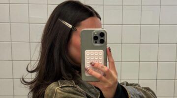 Vrouw maakt een spiegelselfie van haar haar in de spiegel.