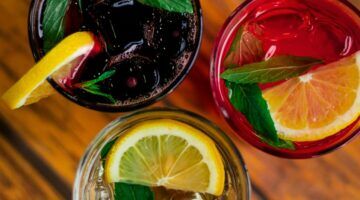 Drie glazen met kleurrijke drankjes er in.