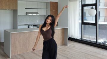 Een vrouw die in haar nieuwe appartement staat.