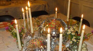 Gedekte tafel met kaarsen en discoballen.
