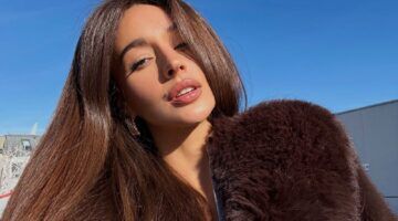 Een vrouw met mooi dik haar poseert voor een selfie.