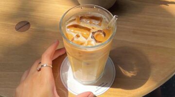 Hand die ijskoffie pakt.