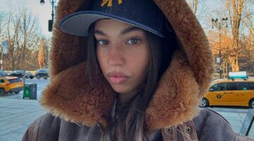 Meisje in winterjas in de sneeuw.