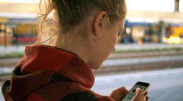 Meisje met telefoon in haar hand.