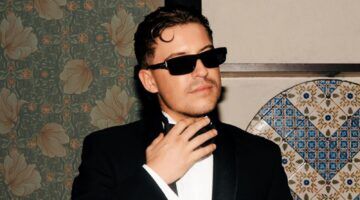 Lil Kleine in pak met een zonnebril op.